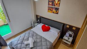 a bedroom with a bed with a red heart pillow at Apartalux Aqua Marina in La Manga del Mar Menor