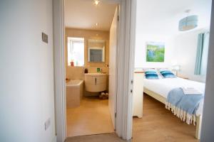 ein Schlafzimmer mit einem Bett und ein Badezimmer mit einem Waschbecken in der Unterkunft Trethvor House FREE PARKING Private bathroom Double in Padstow
