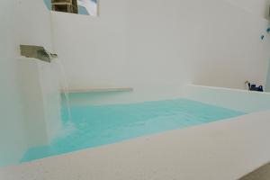 einen Pool mit blauem Wasser in einem Zimmer in der Unterkunft Best Houses 17 - Casa da Saudade in Atouguia da Baleia