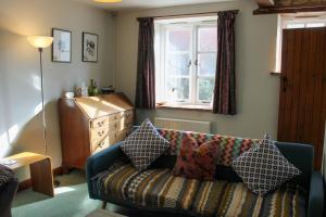 a living room with a couch and a window at Charming Cotswold stone cottage in the Oxfordshire countryside in Banbury