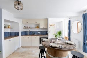 a kitchen with a wooden table and chairs at Suite Bleu d'Azur - Hypercentre - Wifi in Apt +18 photos