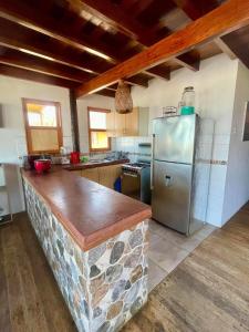 a kitchen with a stone counter and a refrigerator at Casa de playa en Wakama in San Vicente de Cañete
