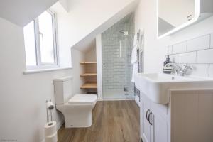 a white bathroom with a toilet and a sink at Woodlands in Charlbury +22 photos
