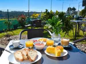 a table with a breakfast of toast and orange juice at Albergue Melide in Melide