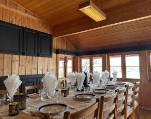 Un comedor con una mesa larga con sillas. en Møsstrond Turisthytte, en Hovden