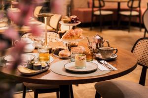 einen Tisch mit Gebäck und Tassen Tee in der Unterkunft Boutique Hotel Malleberg in Brügge