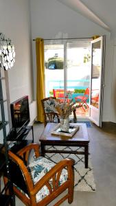 a living room with a table and a tv at FLOREVA 22 entre Plage et Thalasso - Internet fibre in Concarneau