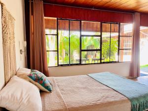 una camera da letto con un letto e una grande finestra di CasaBosque a Tarapoto Altre 30 foto