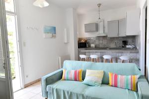 a living room with a blue couch with colorful pillows at Le Miradou in Arles
