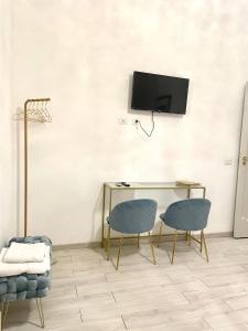 Pokój z 2 krzesłami, biurkiem i telewizorem w obiekcie Salerno Center House - Corso Vittorio Emanuele w mieście Salerno