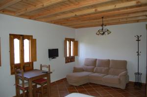 - un salon avec un canapé et une table dans l'établissement La Molinilla Apartamentos y Hammam, à Linares de la Sierra