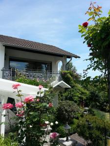 ein Haus mit einem Balkon mit rosa Blumen in der Unterkunft Ferienwohnungen Angela in Bad Marienberg