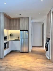una cucina con frigorifero, lavatrice e asciugatrice di Waterfront A La Carte Residence a Ha Long