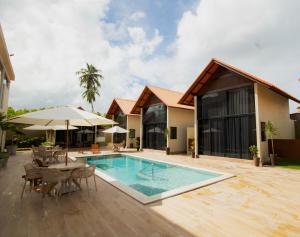a villa with a swimming pool and a house at Villa Aracê in São Miguel dos Milagres