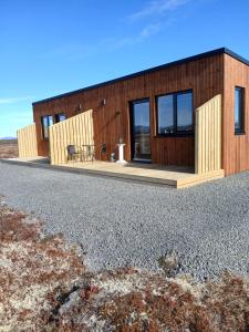 塞尔福斯Pálína Cottage studio的前面设有长凳的木屋