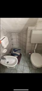 a small bathroom with a toilet and a sink at Cottage Gole Alcantara Sarino in Graniti