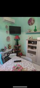 a living room with a table and a kitchen with plates on the wall at Cottage Gole Alcantara Sarino in Graniti