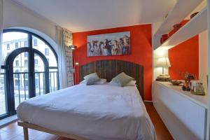 a bedroom with a large bed with an orange wall at Maison Clocher in Pré-Saint-Didier