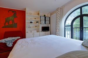 a bedroom with a white bed and a red wall at Maison Clocher in Pré-Saint-Didier +5 photos