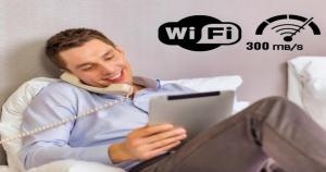 a man sitting on a bed with a tablet at Miramonti Simple Stay in Turin
