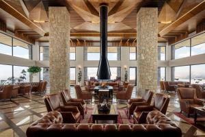 RawandozRadisson Blu Resort & Spa, Korek Mountain的大堂设有皮椅、桌子和窗户。