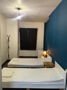 two beds in a room with a blue wall at Family Hostel and Tours in Yerevan