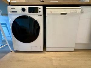 a white washing machine next to a white dishwasher at LA BADINE Appartement 5 personnes avec balnéo et clim in Hyères