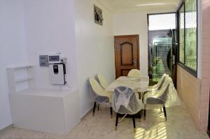 a dining room with a table and chairs at Résidence CHEZ TIMERA in Keur Massar