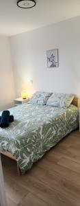 a bed with a green and white comforter in a bedroom at Le maillot VII in Castres