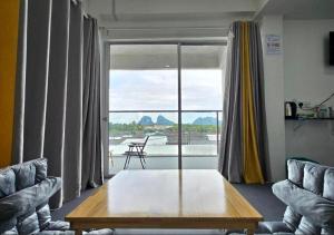 a living room with a table and a large window at 365 Resorts in Kaki Bukit