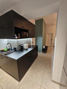 a kitchen with black cabinets and a counter top at 7Wygodny pokoj w centrum Wroclawia in Wrocław