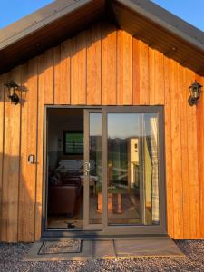 a wooden building with a sliding glass door at The Wee Knoll in Invergarry
