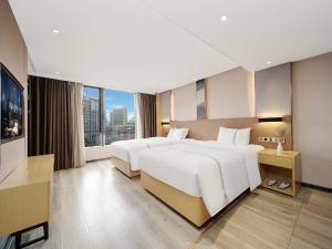 a hotel room with two beds and a large window at Yishang Hotel - Guangzhou Railway Station Yuexiu Park Subway Station in Guangzhou +19 photos