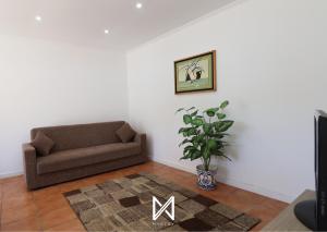 ein Wohnzimmer mit einer Couch und einer Pflanze in der Unterkunft MyStay - Casa do Telhal in Vila Nova de Gaia