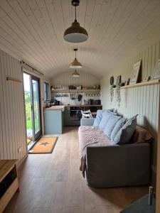 a living room with a couch and a kitchen at The Roost at Broadgates in Totnes