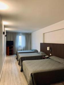 a hotel room with three beds and a television at Cristal Palace Hotel in Buenos Aires +19 photos