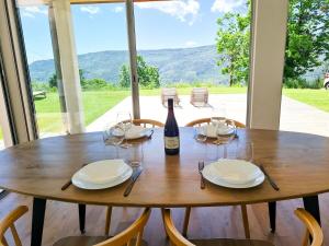 a wooden table with glasses and a bottle of wine at Villa Californienne au calme in Berre-les Alpes