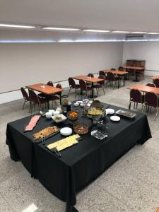 a black table with food on it with tables and chairs at Cristal Palace Hotel in Buenos Aires