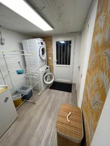 a laundry room with a washing machine and a door at Maison Jardin Proche Paris in Sainte-Geneviève-des-Bois