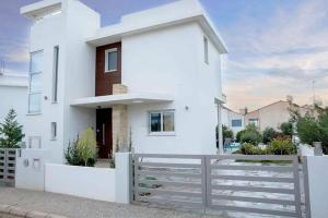 ein weißes Haus mit einem Zaun in der Unterkunft Aqua Luxe Konnos Beach Ayia Napa Protaras Villa with Sea view in Protaras