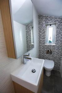 ein Badezimmer mit Waschbecken, Toilette und Spiegel in der Unterkunft Aqua Luxe Konnos Beach Ayia Napa Protaras Villa with Sea view in Protaras