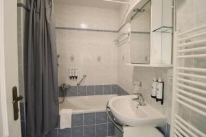 a bathroom with a sink and a bath tub at Apartmá Justina 1880 in Karlovy Vary