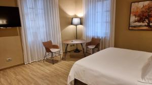 a hotel room with a bed and a table and chairs at Albergo Trieste Boves - Ricetto Suite in Boves