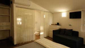 a living room with a couch and a sliding glass door at Onda Marina B&B Superior in Marano Lagunare