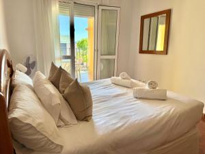 een slaapkamer met een wit bed met handdoeken erop bij Apartamento Milenio Nerja in Nerja +7 foto's