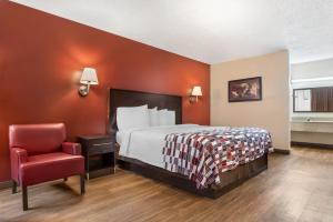 a hotel room with a bed and a chair at Red Roof Inn Montgomery - Midtown in Montgomery