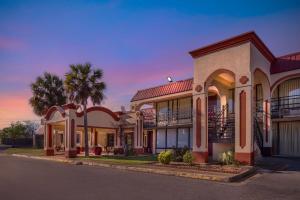 a row of houses with palm trees and a street at Red Roof Inn Montgomery - Midtown in Montgomery