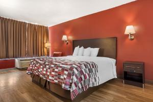 a hotel room with a bed and a red wall at Red Roof Inn Montgomery - Midtown in Montgomery +14 photos