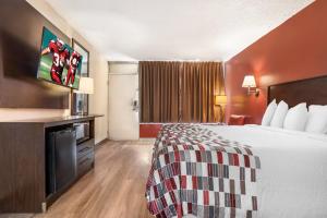 a hotel room with a bed and a flat screen tv at Red Roof Inn Montgomery - Midtown in Montgomery