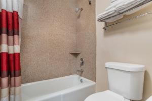 a bathroom with a toilet and a tub and a shower at Red Roof Inn Montgomery - Midtown in Montgomery